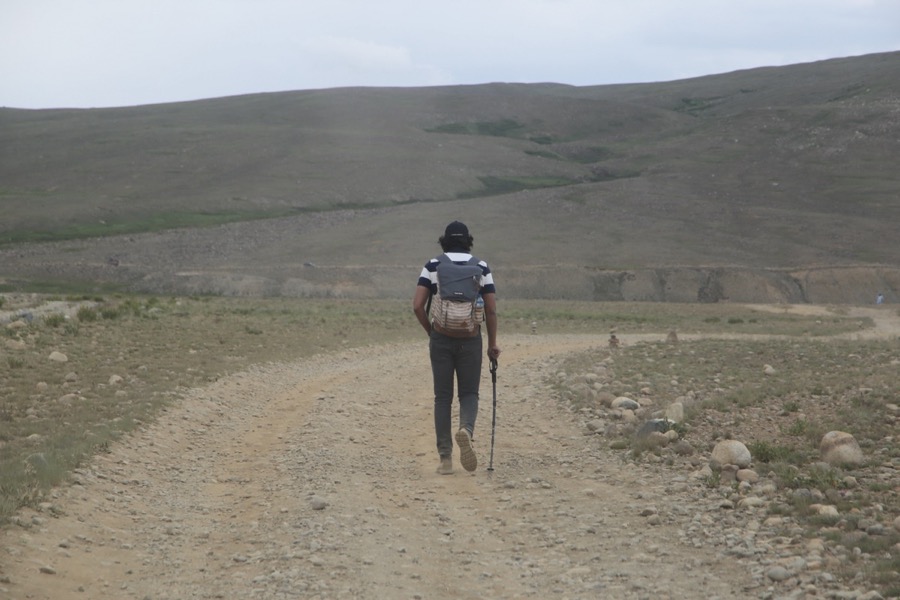 Talha hiking alone on a mountain trail with a trekking pole